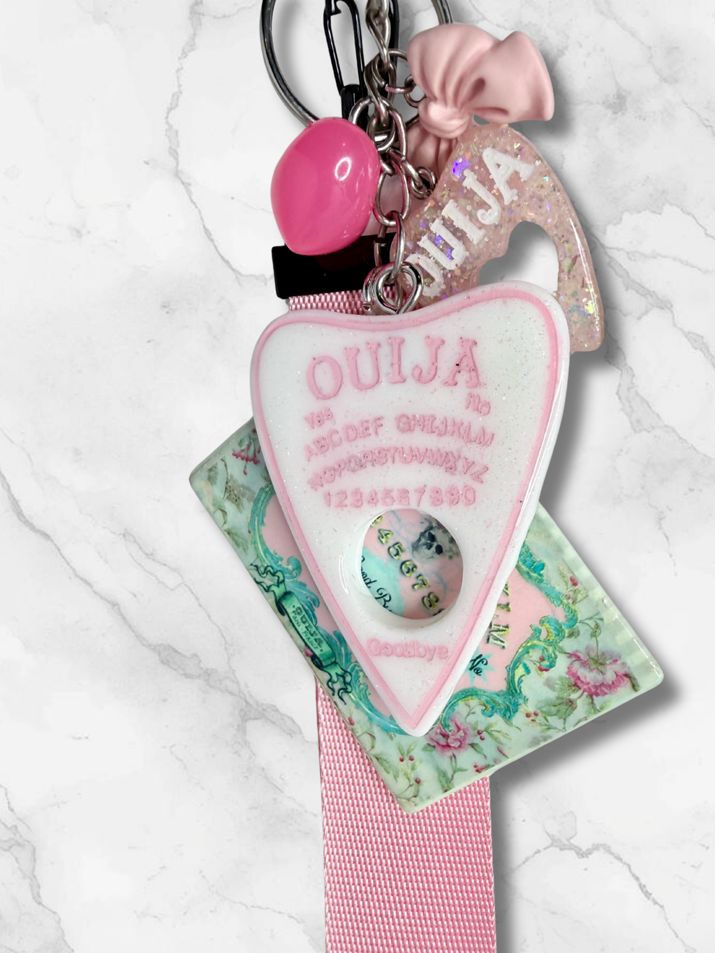 Adorrible Ouija Board keychain with wristlet and spooky charms, featuring a small Ouija board pendant and decorative charms.