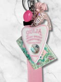 Adorrible Ouija Board keychain with wristlet and spooky charms, featuring a small Ouija board pendant and decorative charms.