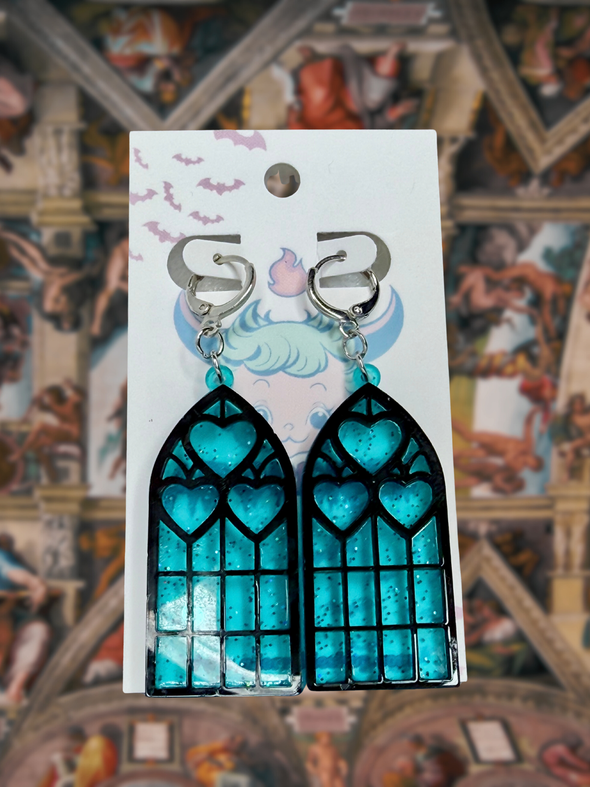 Adorrible Cathedral of Love acrylic dangle earrings with intricate design and vibrant colors, hanging from silver hooks.