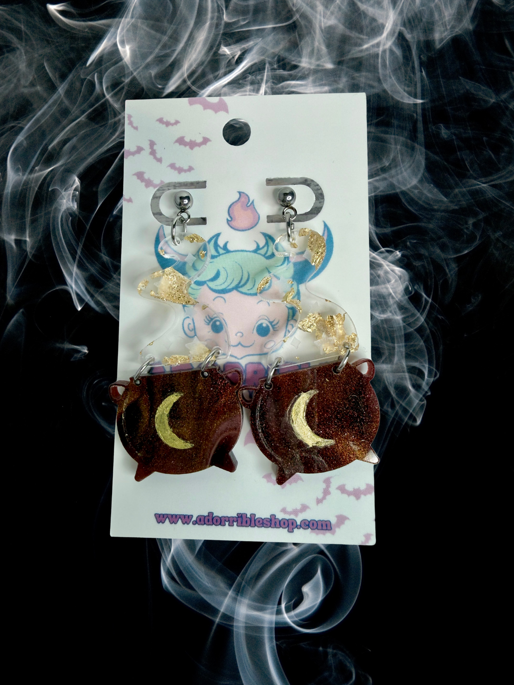 Adorrible witch’s cauldron earrings featuring small black cauldrons with bubbling green potion details.