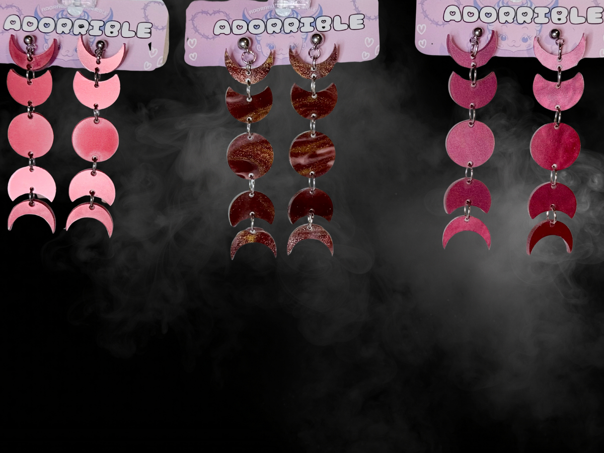 Adorrible moon phases earrings featuring a celestial design with different moon cycle images in silver-tone metal.