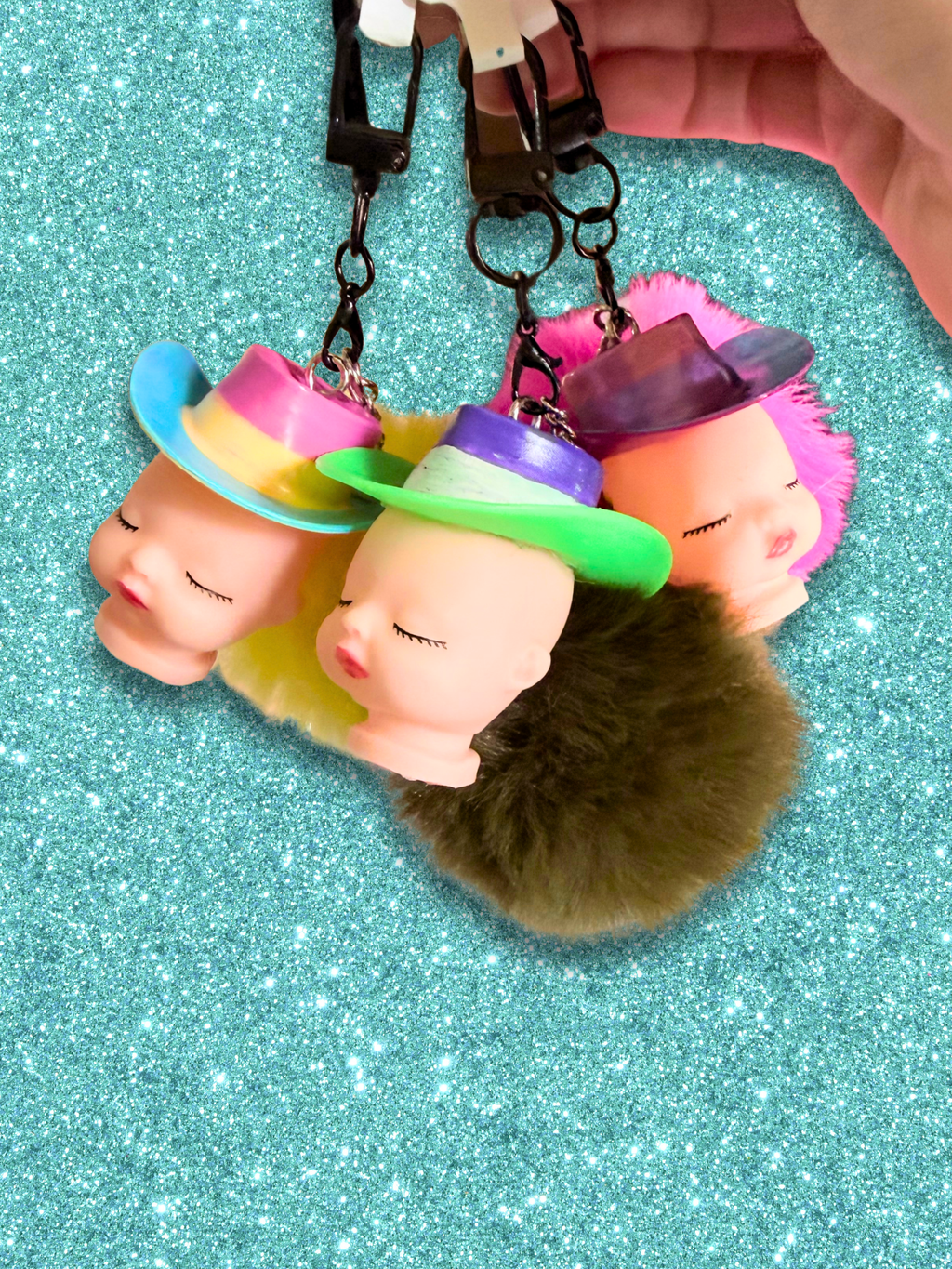 Adorrible Pride cowboy hat baby doll head keychain with colorful cowboy hat and detailed doll face on a silver keyring