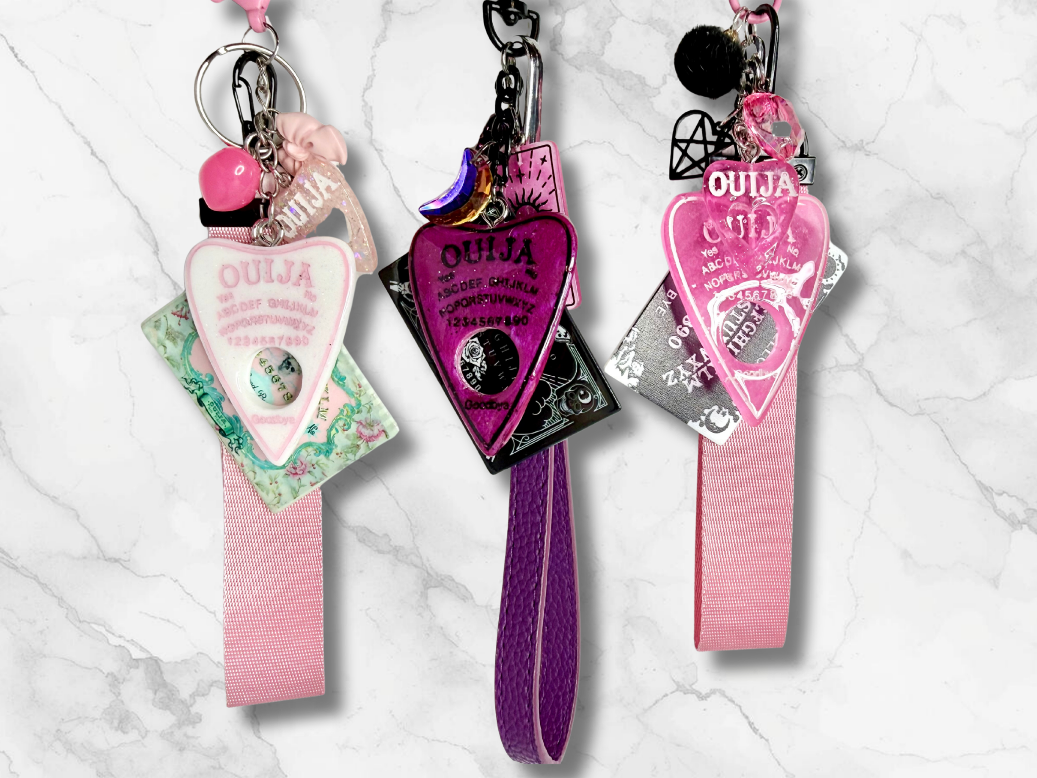 Adorrible Ouija Board keychain with wristlet and spooky charms, featuring a black and white Ouija design and ghostly accents.