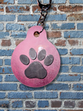 Adorrible paw-shaped keychain with a metal keyring, featuring a cute, detailed paw print design on a silver-tone metal surface.