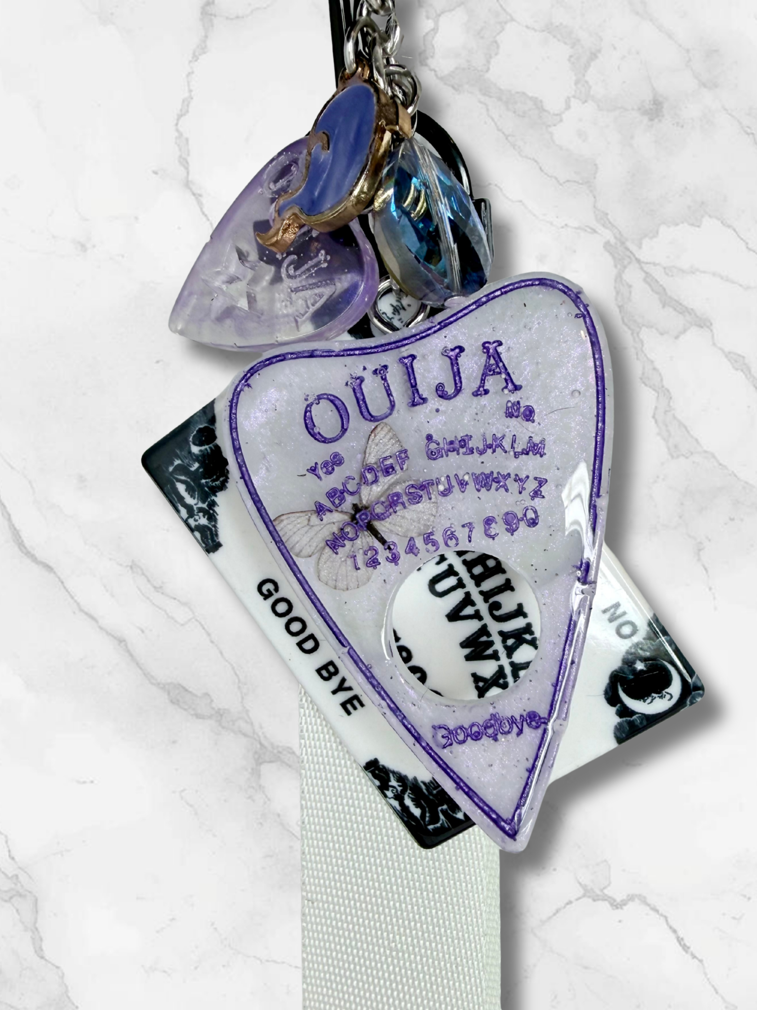 Adorrible Ouija Board keychain with wristlet and spooky charms, featuring mystical symbols and decorative elements.