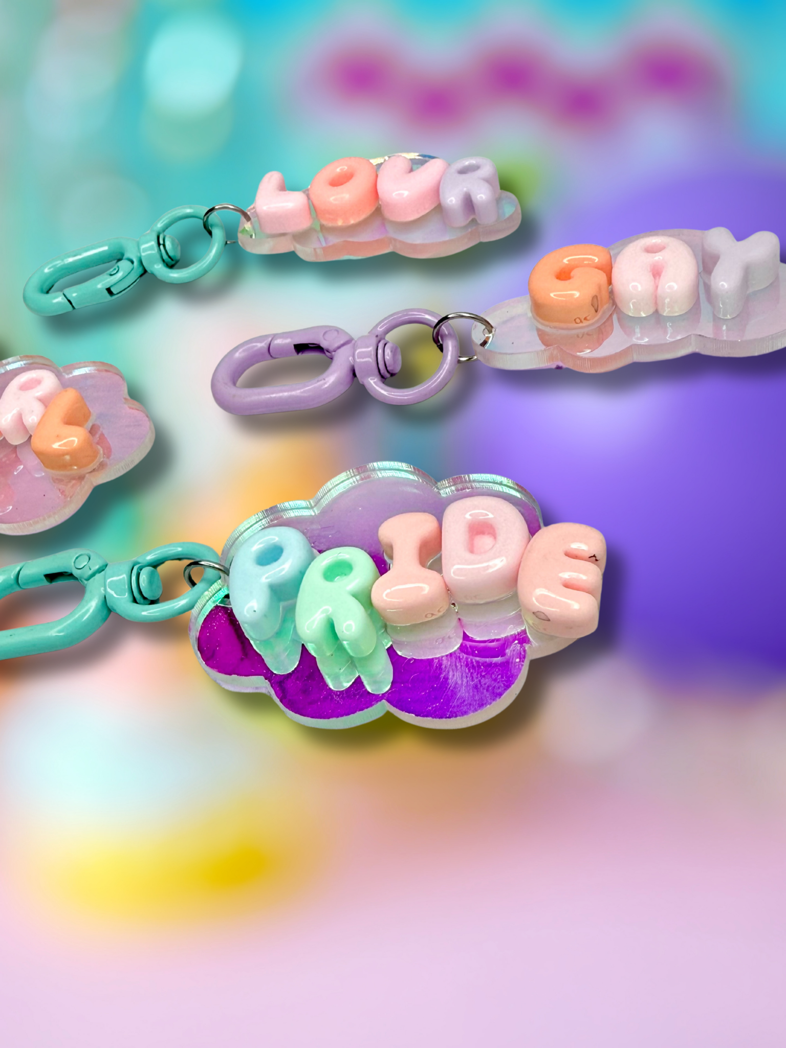 Iridescent cloud-shaped bubble letter keychain by Adorrible with shiny, colorful finish and a metal keyring attachment.