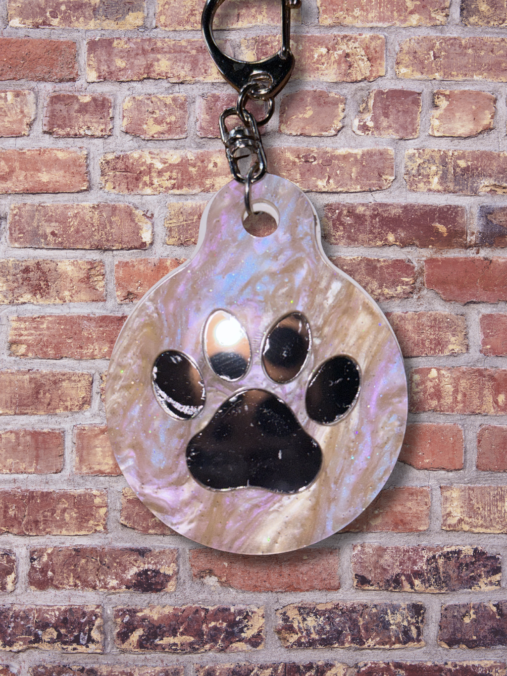 Adorrible paw-shaped keychain with detailed paw print design on a metal ring for keys or accessories.