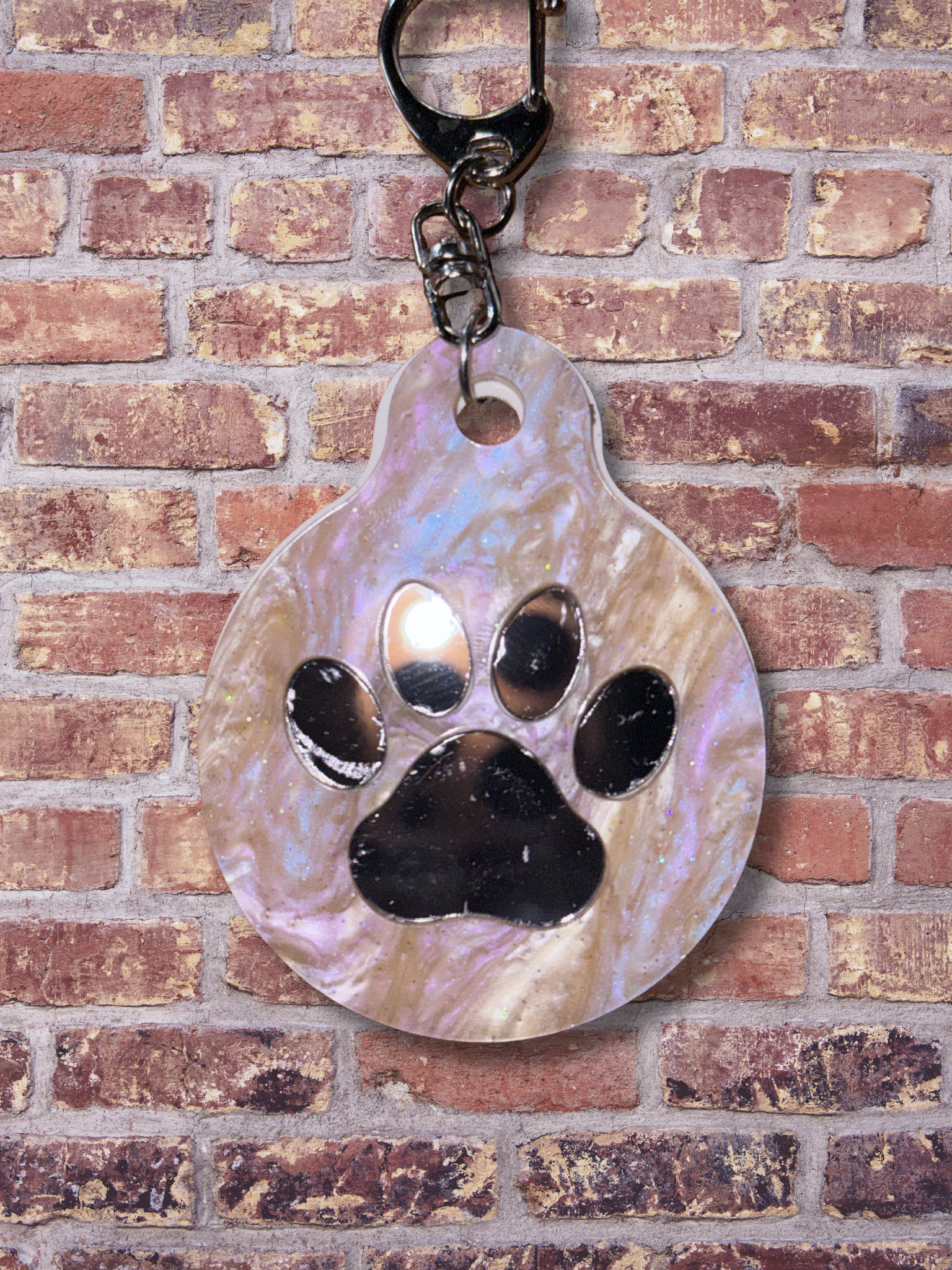 Adorrible paw-shaped keychain with detailed paw print design on a metal ring for keys or accessories.
