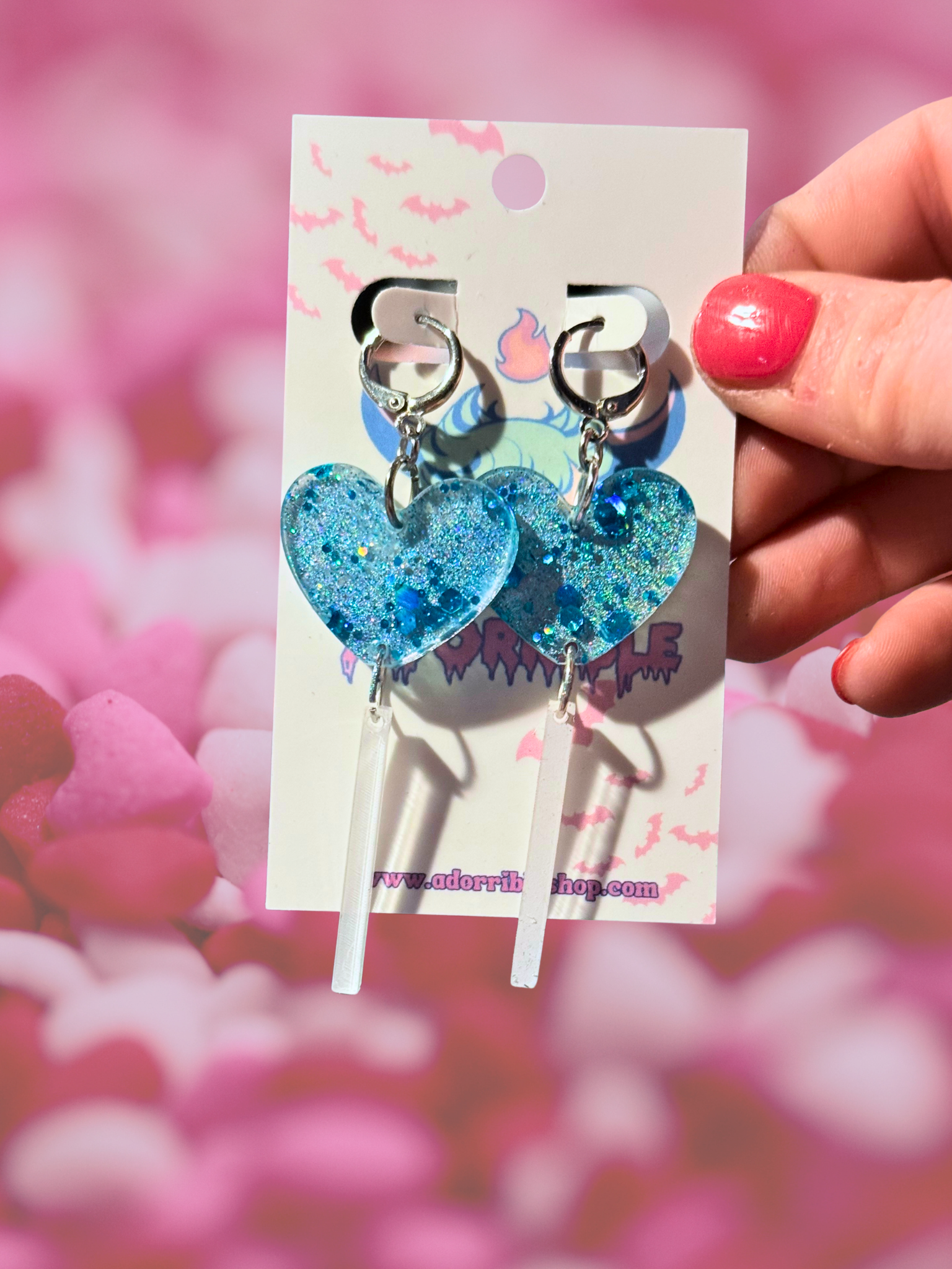 Adorrible heart-shaped acrylic dangle earrings with gold-tone hooks, featuring vibrant red and pink heart designs.