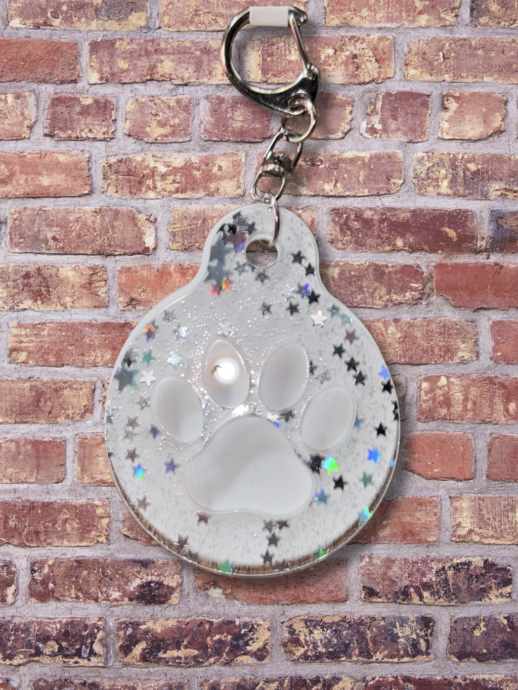 Adorrible paw-shaped keychain with a cute, detailed design on a neutral background.
