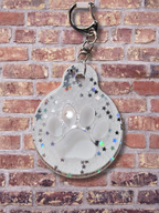 Adorrible paw-shaped keychain with a cute, detailed design on a neutral background.
