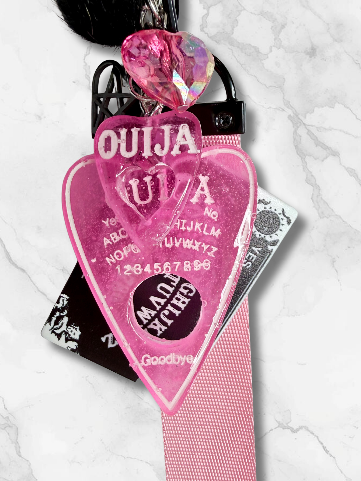Adorrible Ouija Board keychain with wristlet and spooky charms, featuring mystical symbols and a compact, portable design.