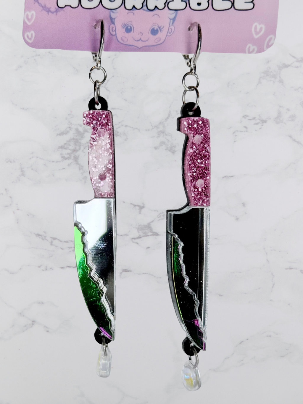 Layered bloody dagger earrings by Adorrible featuring dangling knife design with layered metal and gothic style.