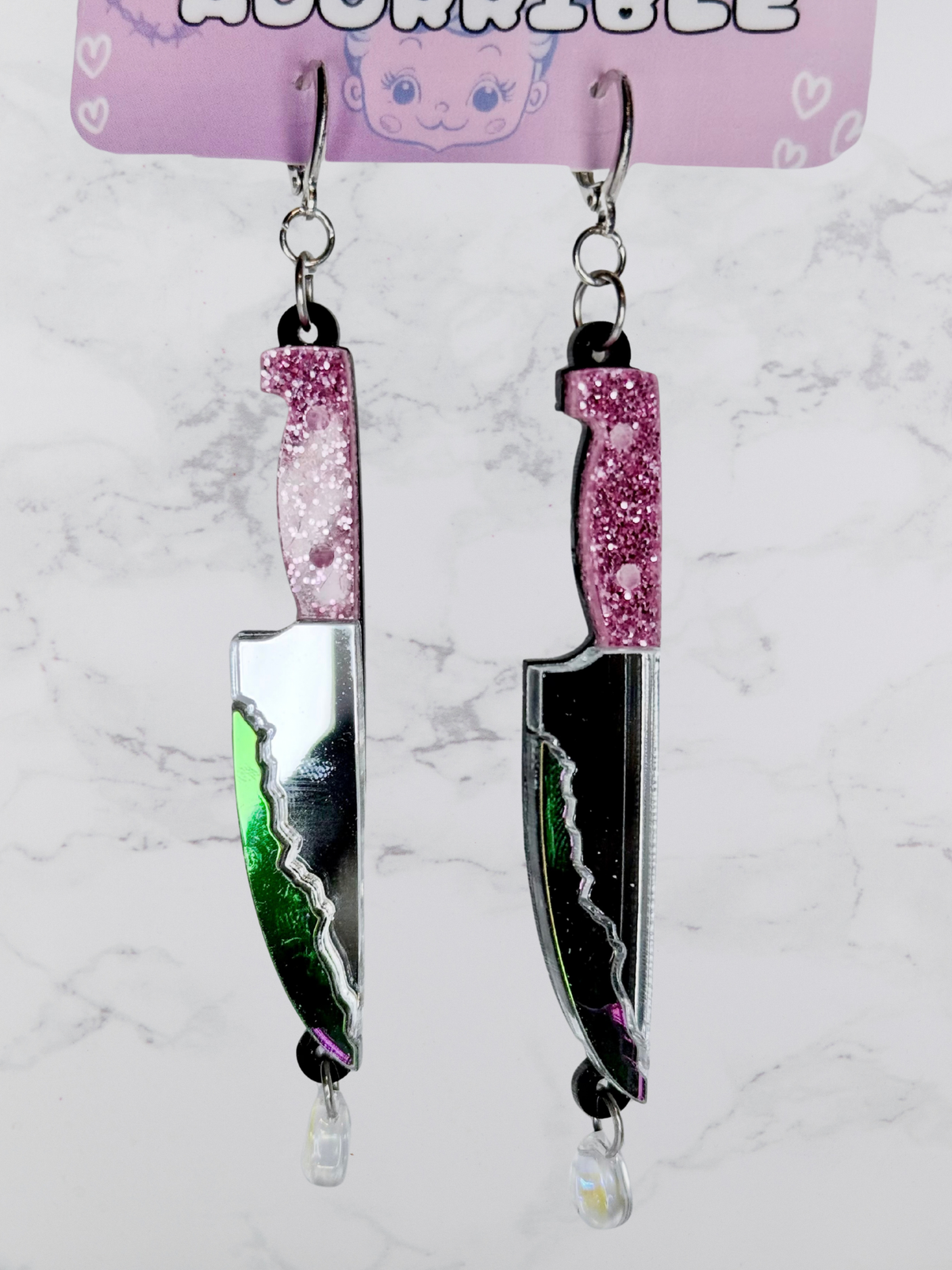 Layered bloody dagger earrings by Adorrible featuring dangling knife design with layered metal and gothic style.