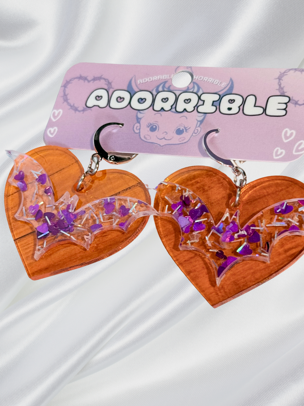 Adorrible Batty Heart earrings featuring heart-shaped design with bat motifs, silver-tone metal, and detailed craftsmanship.