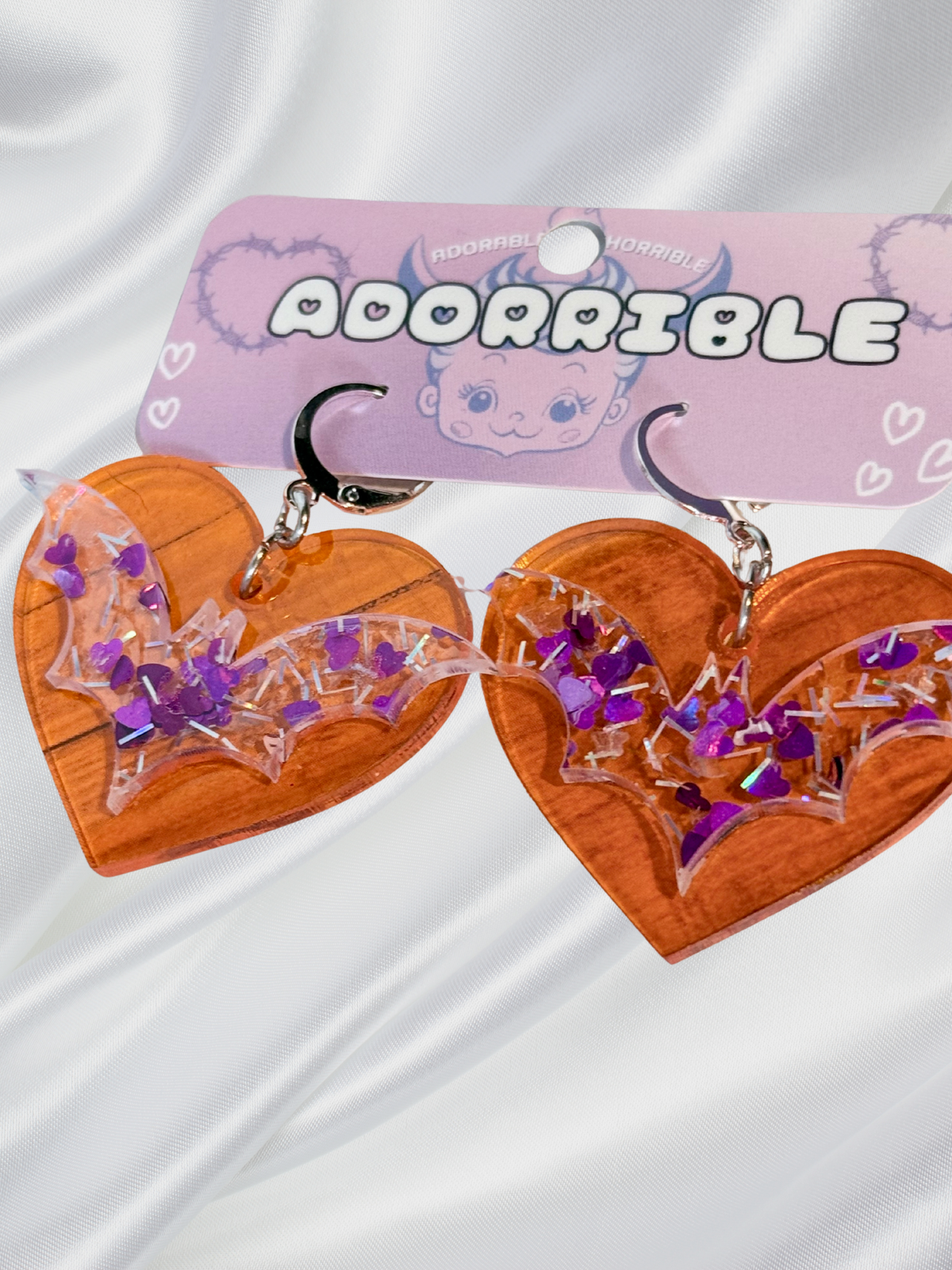 Adorrible Batty Heart earrings featuring heart-shaped design with bat motifs, silver-tone metal, and detailed craftsmanship.