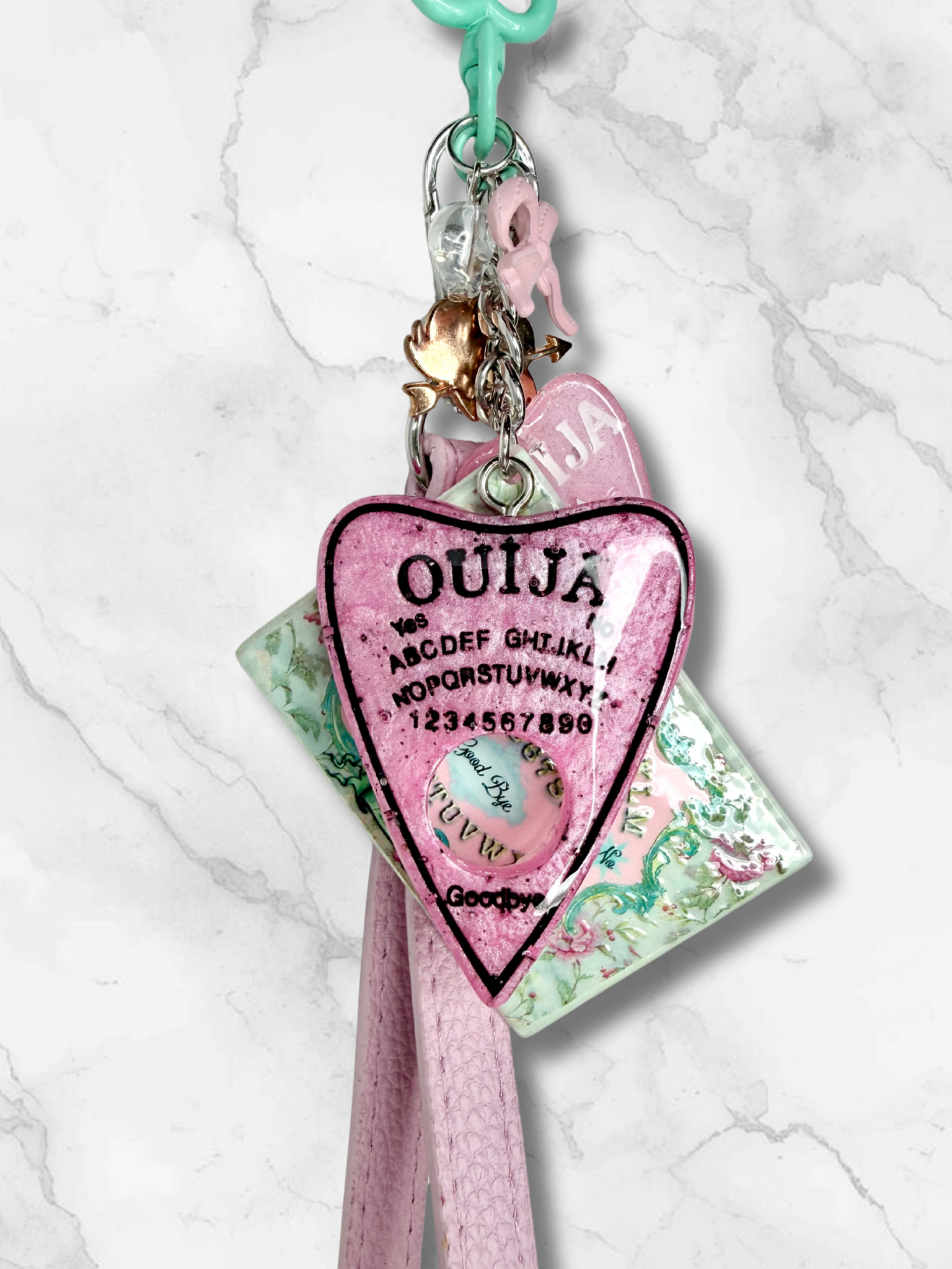 Adorrible Ouija Board keychain with wristlet and spooky charms, featuring a miniature Ouija board design and decorative charms.