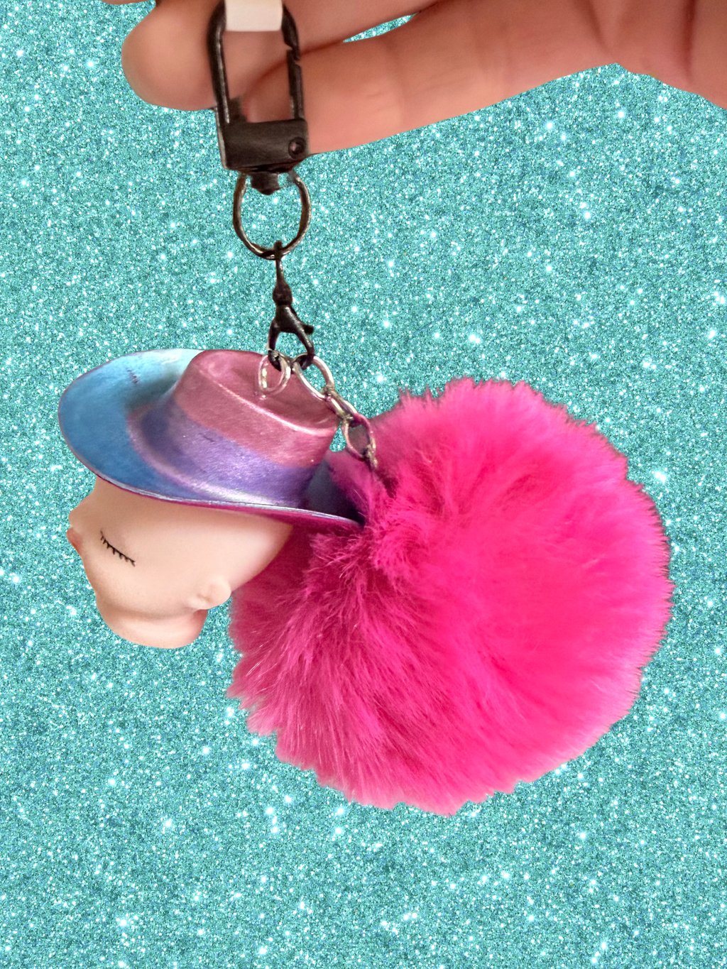 Adorrible Pride cowboy hat baby doll head keychain showing colorful miniature doll face with cowboy hat attachment.