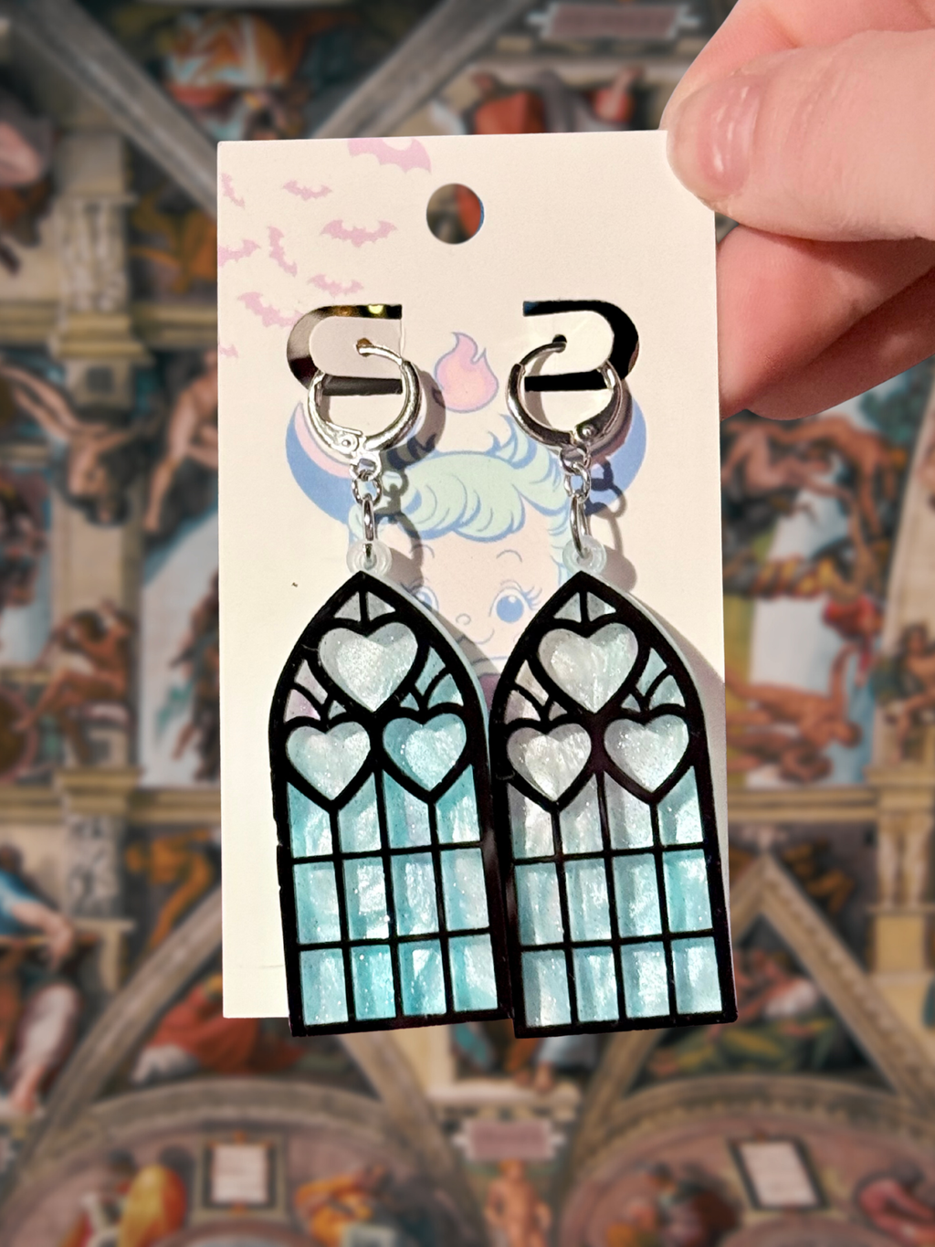 Adorrible Cathedral of Love acrylic dangle earrings featuring intricate geometric design on a neutral background.