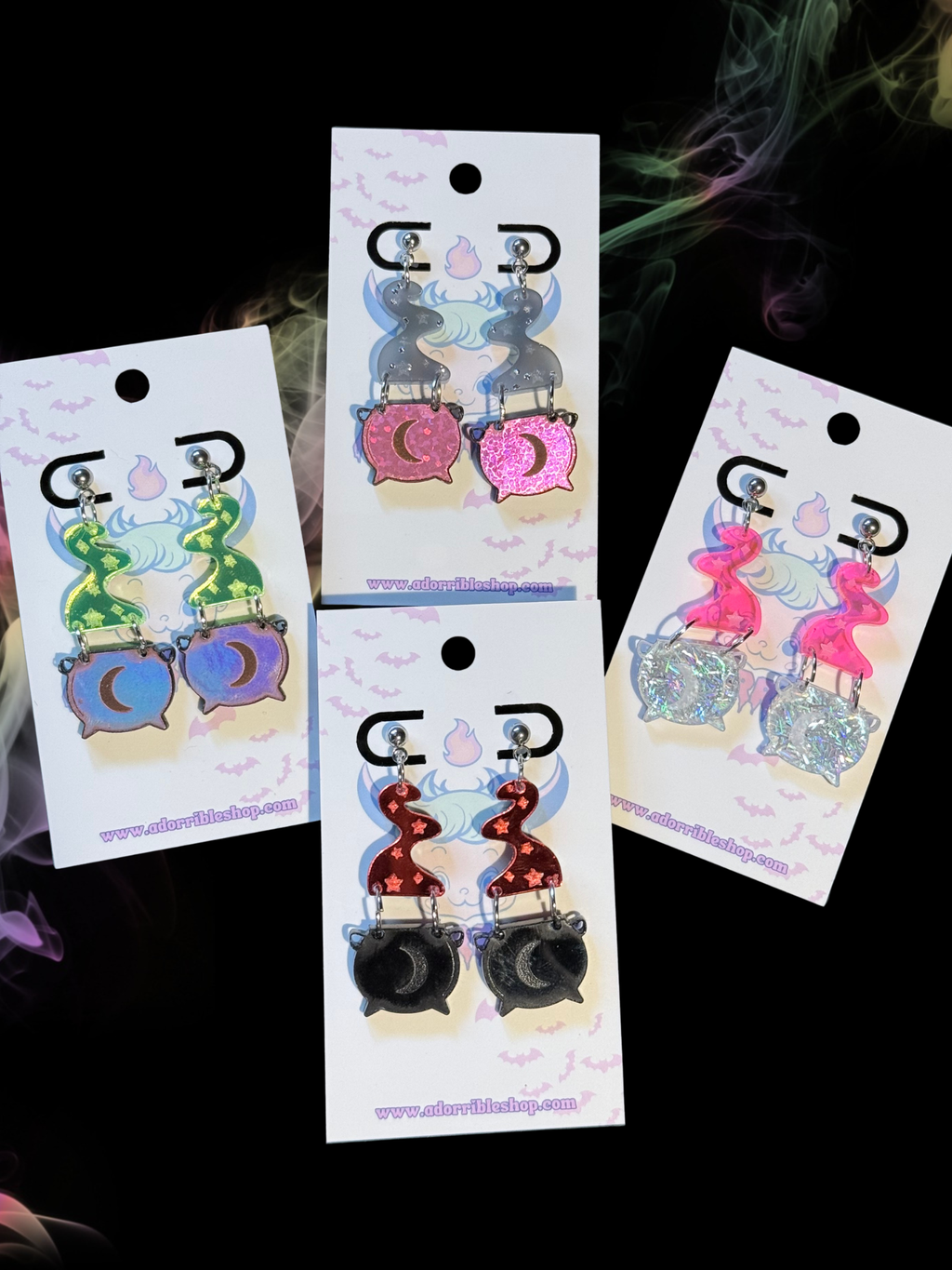 Mini witch’s cauldron earrings by Adorrible featuring small black cauldron charms with silver hooks.