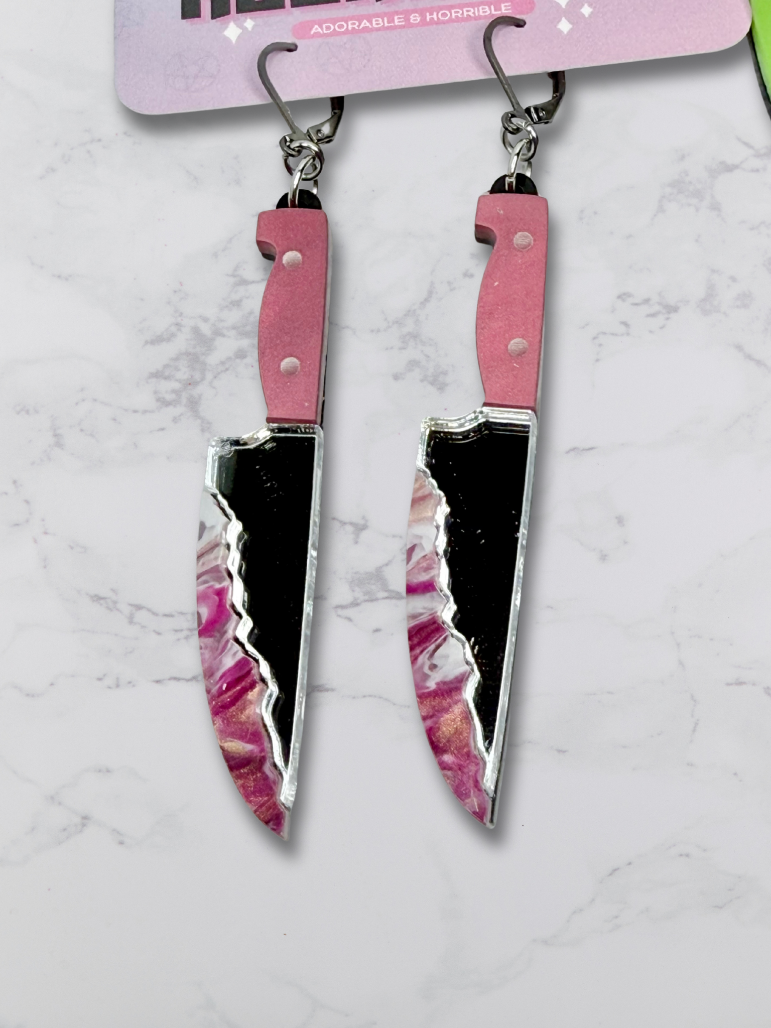 Layered bloody dagger earrings by Adorrible featuring dangling knife designs with a gothic, edgy style.