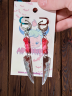 Adorrible two-part bloody knife earrings featuring realistic dagger design with blood-splattered details on silver-toned metal.