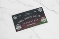 Humorous Ouija board sticker with a shiny holographic finish, perfect for adding fun and sparkle to your space