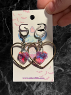 Heart-shaped hoop earrings with sparkling heart crystals by Adorrible, featuring shiny metal hoops and delicate crystal accents.