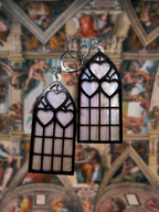Adorrible Cathedral of Love acrylic dangle earrings featuring intricate design and vibrant colors, hanging from silver hooks.