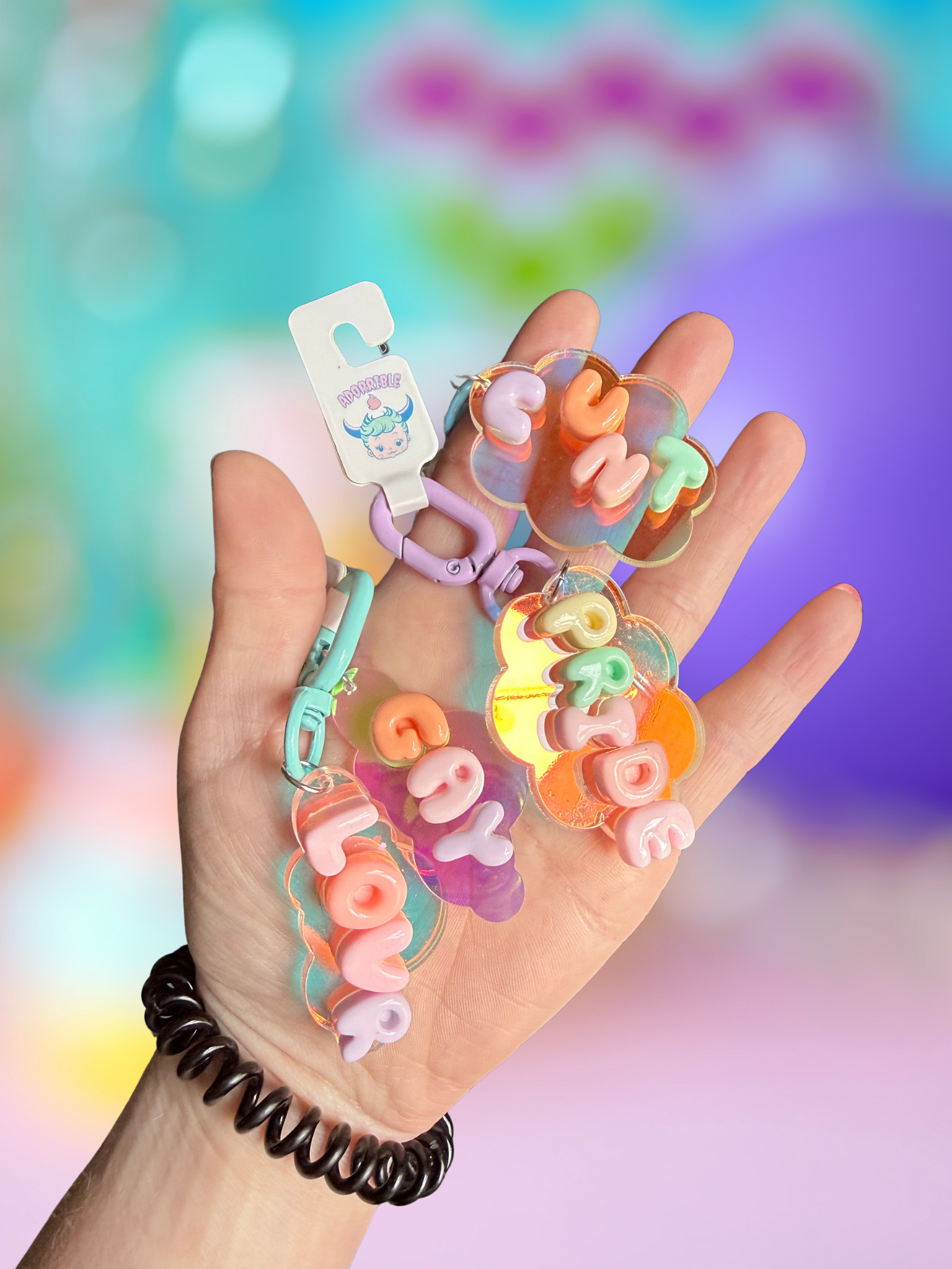 Iridescent cloud keychain with bubble letter design from Adorrible, featuring shiny, colorful cloud shape on a metal keyring.