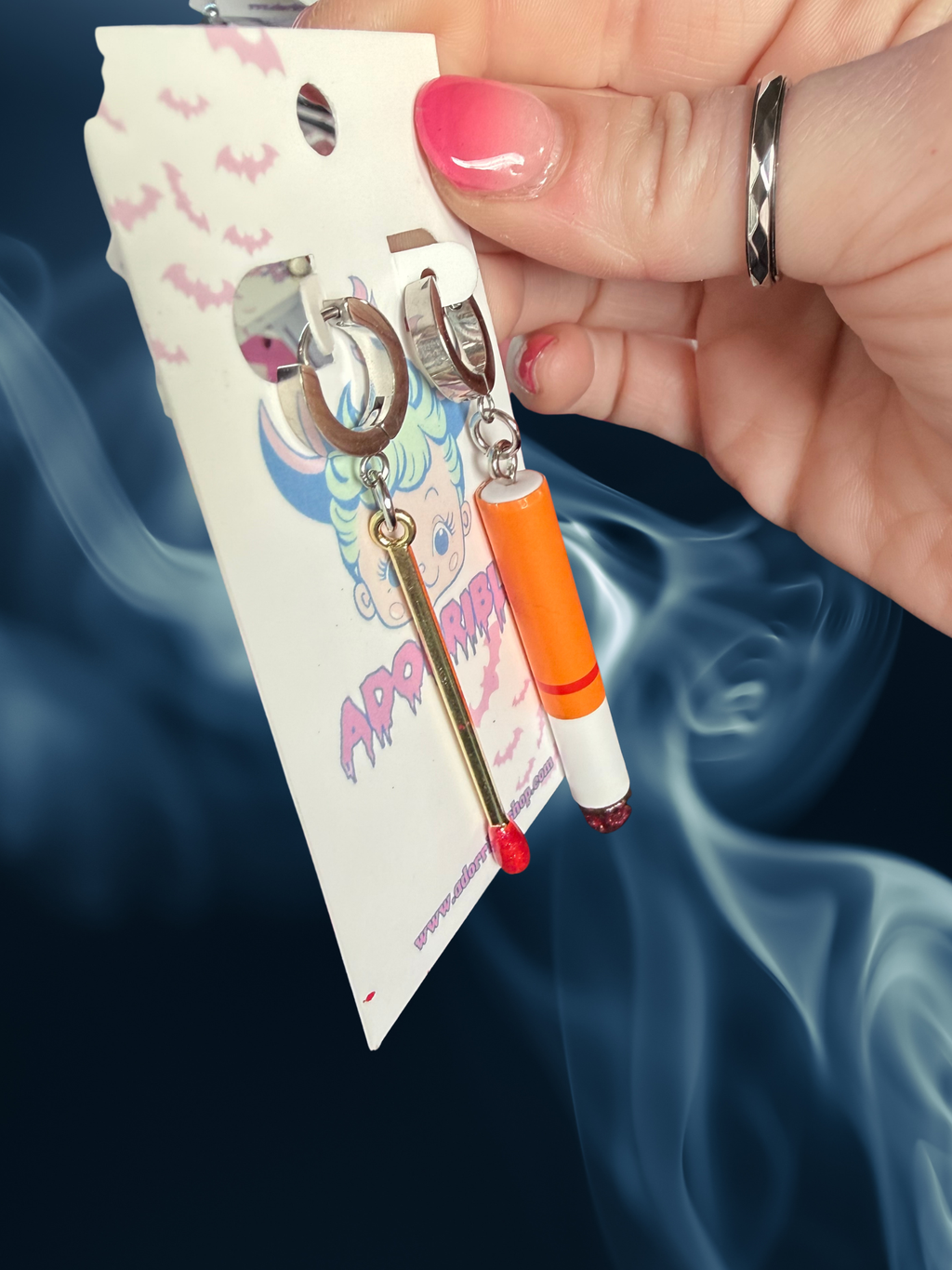 Adorrible mismatched cigarette and match earrings, gold-tone jewelry with detailed design, on a white background.